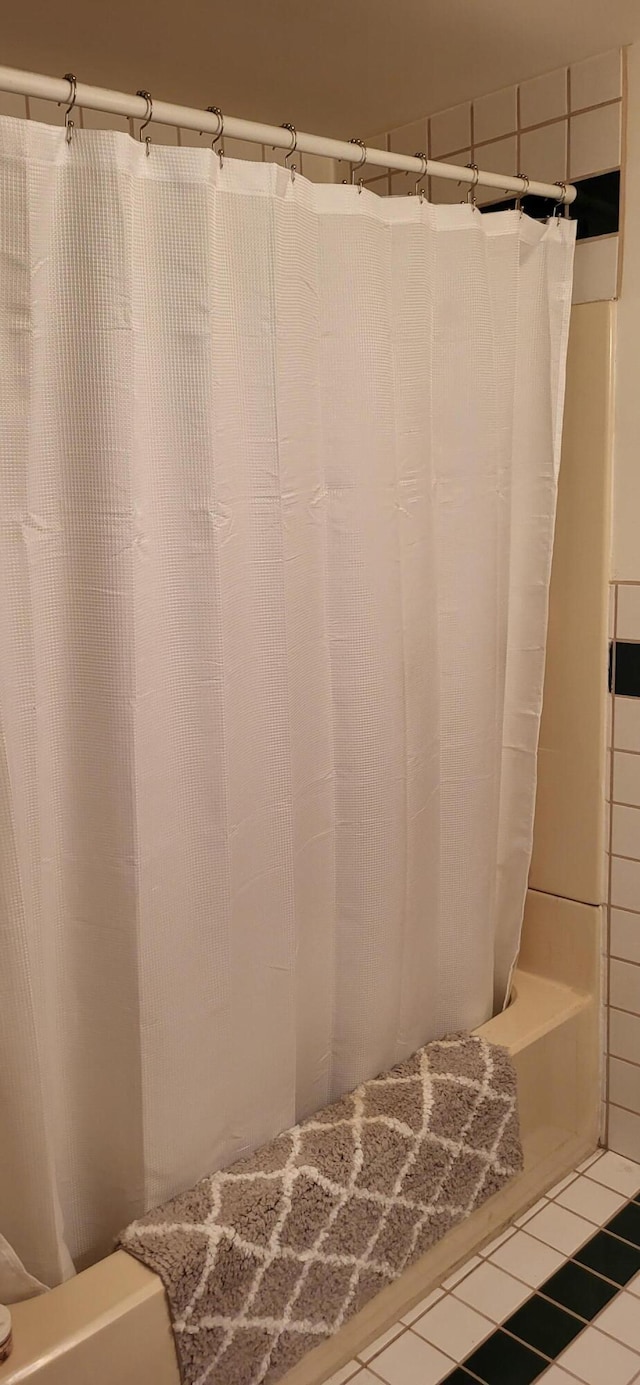 bathroom featuring shower / bath combo and tile patterned flooring