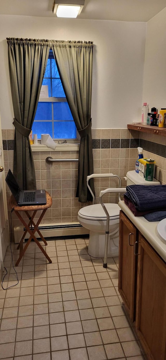 bathroom featuring tile walls, vanity, tile patterned flooring, toilet, and a baseboard radiator