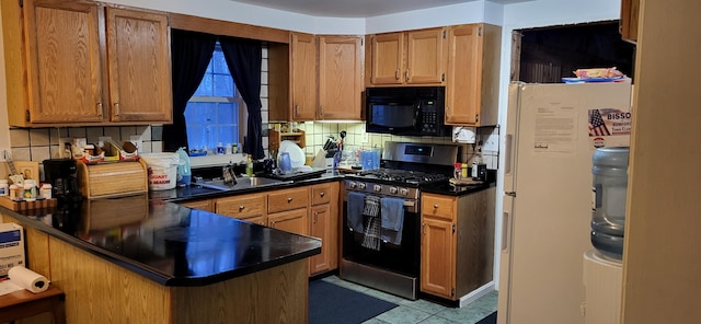 kitchen with kitchen peninsula, stainless steel range with gas stovetop, sink, backsplash, and white fridge