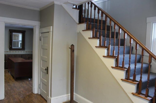 stairs with crown molding and dark hardwood / wood-style flooring