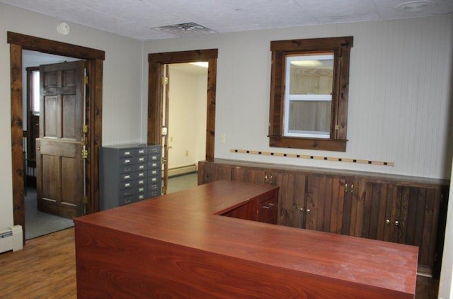 home office with baseboard heating and wood-type flooring