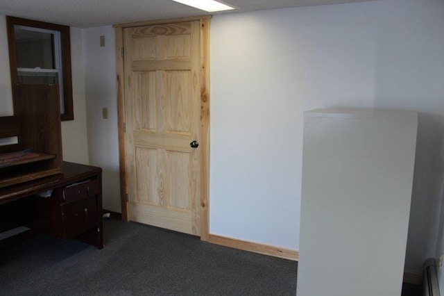 bedroom featuring baseboard heating and dark colored carpet