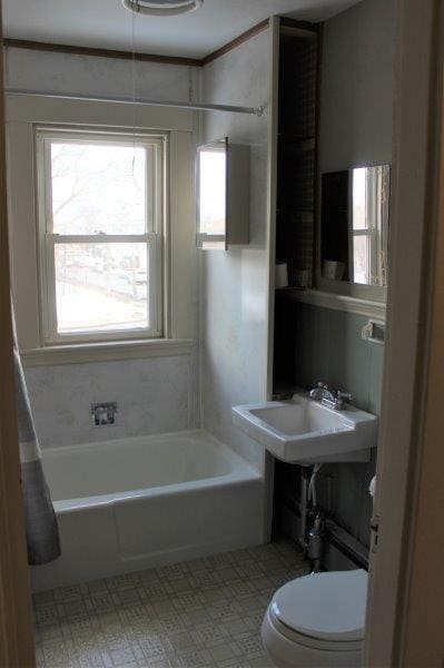 bathroom featuring toilet, tile floors, and shower / tub combination