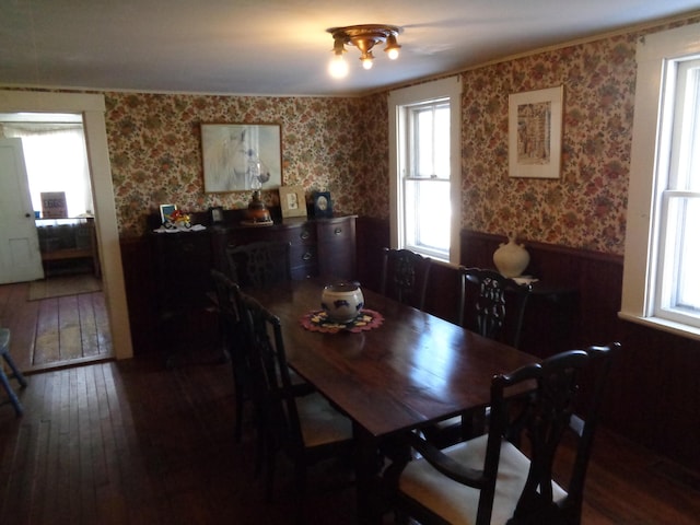 dining space featuring wallpapered walls and hardwood / wood-style floors