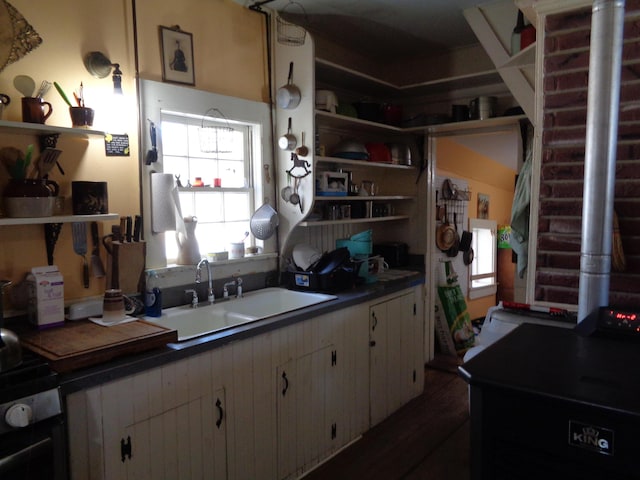 kitchen featuring a sink, white cabinets, black range with electric cooktop, and open shelves