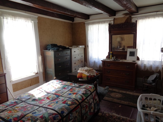 bedroom featuring beam ceiling and multiple windows