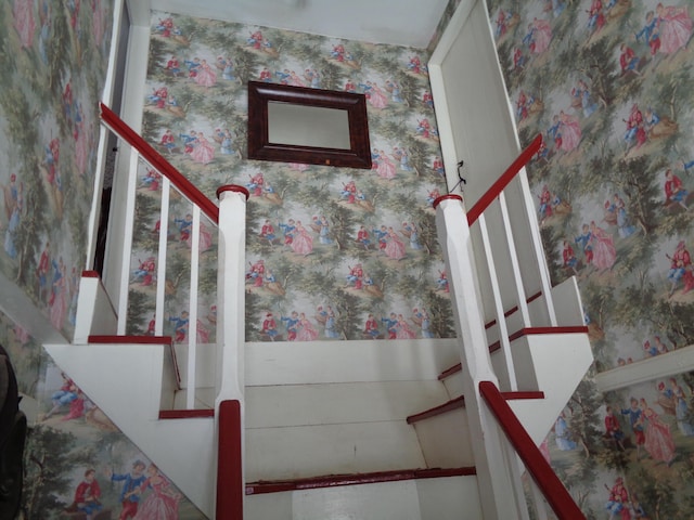 stairs featuring wallpapered walls