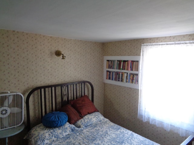 bedroom with multiple windows and wallpapered walls