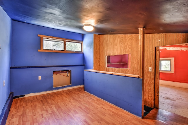 interior space featuring hardwood / wood-style floors, wood walls, and a healthy amount of sunlight