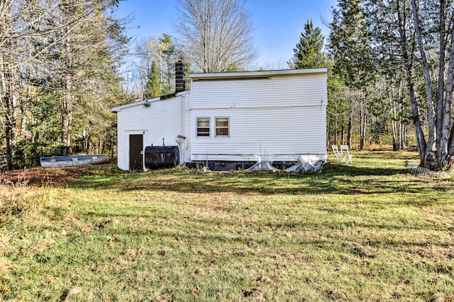 rear view of property featuring a lawn