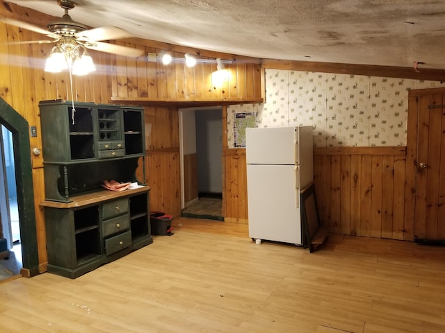 kitchen featuring a textured ceiling, light hardwood / wood-style flooring, ceiling fan, and white fridge