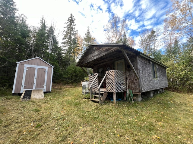 back of house featuring a yard and a shed