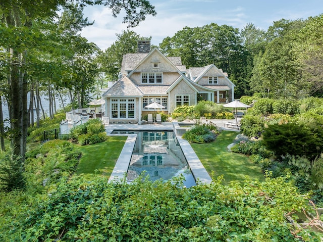 29 Summerhaven Ln, Boothbay, ME 04544 - back of house with a chimney, an outdoor pool, a lawn, and a patio area