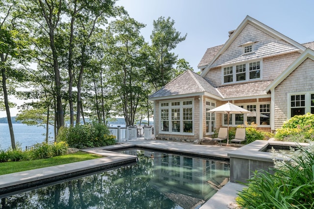 29 Summerhaven Ln, Boothbay, ME 04544 - back of property with an outdoor pool, a patio area, a chimney, and a water view