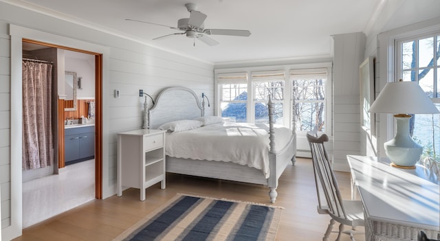 29 Summerhaven Ln, Boothbay, ME 04544 - bedroom with light wood finished floors, ornamental molding, wooden walls, a ceiling fan, and ensuite bathroom