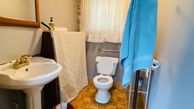 bathroom featuring toilet and parquet floors