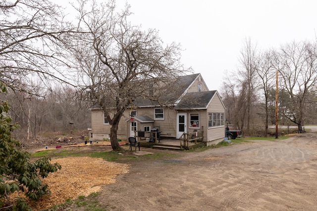 rear view of house featuring a wooden deck