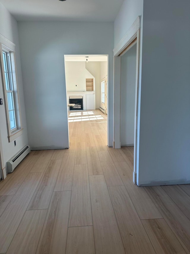 hallway featuring a baseboard radiator and light hardwood / wood-style floors