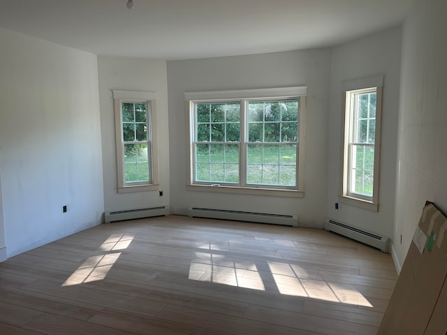 spare room with a baseboard radiator and light hardwood / wood-style floors