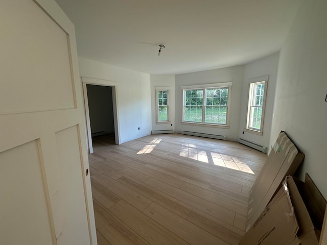 unfurnished room with light hardwood / wood-style floors and a baseboard radiator