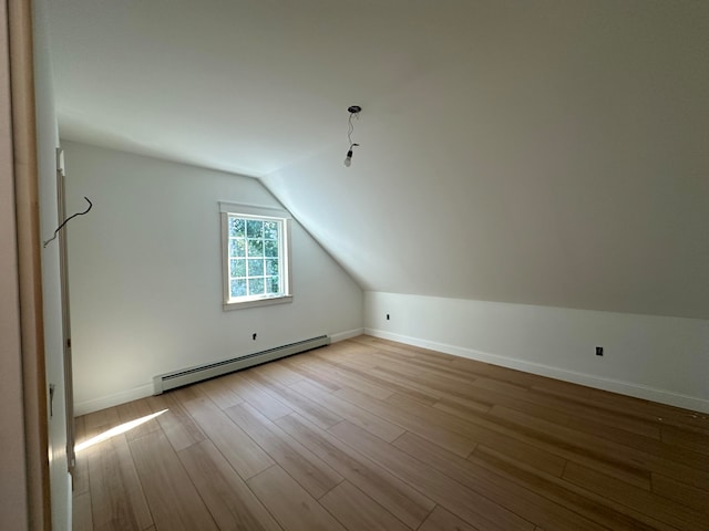 bonus room featuring vaulted ceiling, a baseboard radiator, and light wood-type flooring