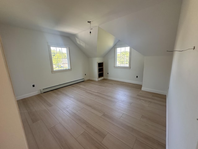 bonus room featuring light wood finished floors, baseboards, lofted ceiling, and a baseboard radiator