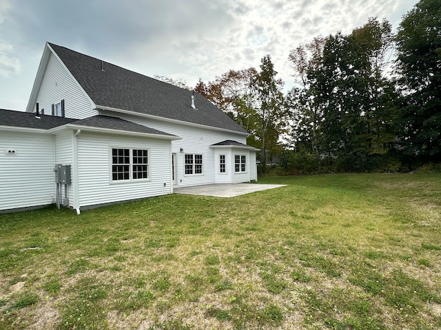 back of property featuring a patio area and a lawn