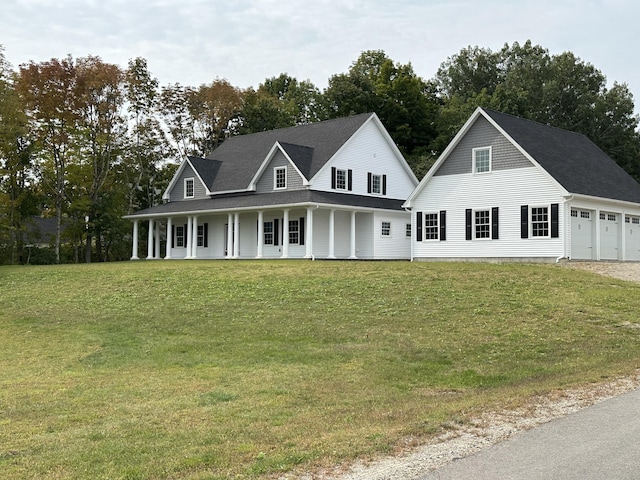 view of front of property with an attached garage, covered porch, and a front lawn