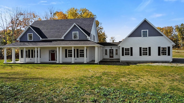 back of property featuring covered porch and a lawn