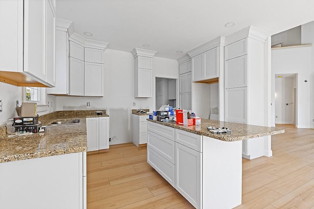 kitchen featuring light hardwood / wood-style floors, a kitchen island, and white cabinets