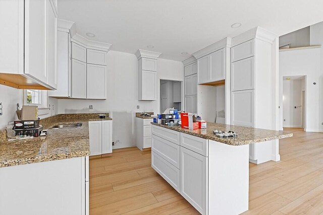 LOT1 Honey Hill Ests W, Hampden, ME 04444 - kitchen featuring stone countertops, light wood-style floors, a kitchen island, and white cabinets
