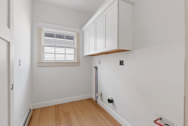 laundry area with light hardwood / wood-style floors, cabinets, and a baseboard radiator