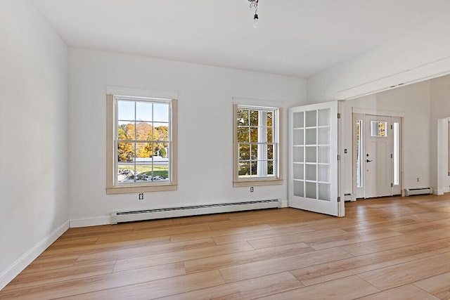 spare room with light hardwood / wood-style flooring and a baseboard heating unit