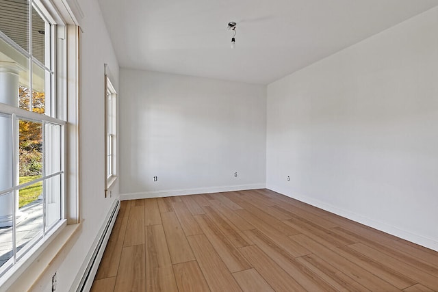 unfurnished room with light hardwood / wood-style floors and a baseboard radiator