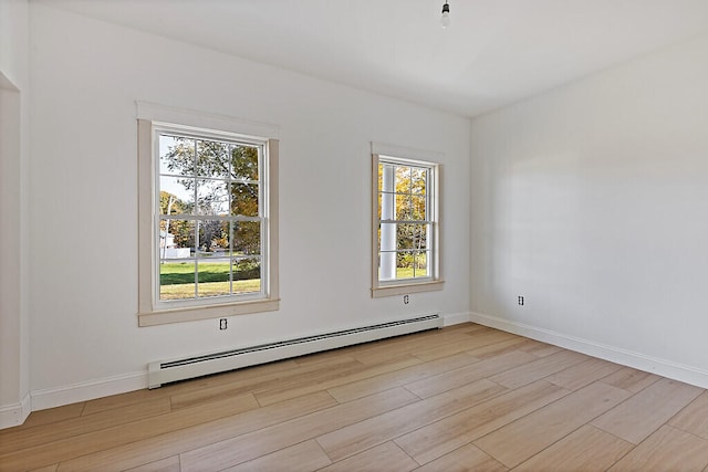 spare room with light hardwood / wood-style floors, a healthy amount of sunlight, and baseboard heating