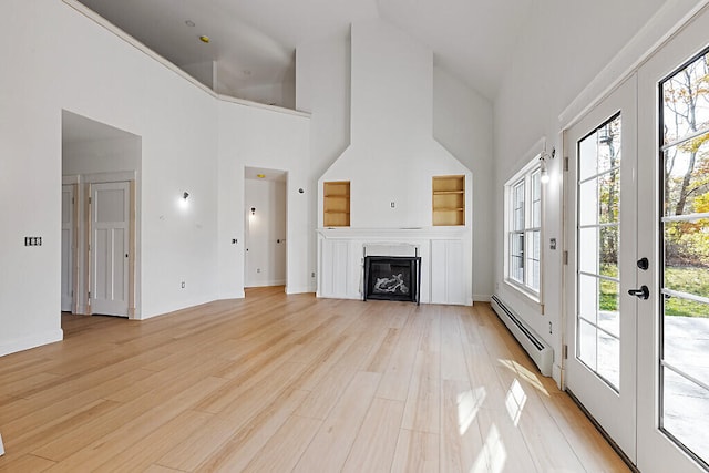 unfurnished living room featuring a baseboard radiator, high vaulted ceiling, french doors, and light hardwood / wood-style flooring