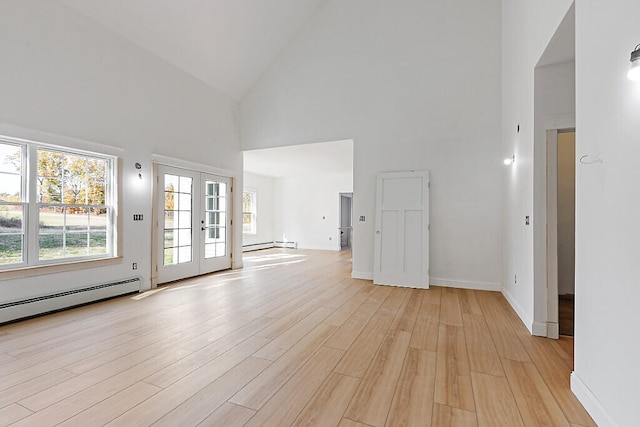 unfurnished living room featuring a baseboard radiator, french doors, light hardwood / wood-style floors, and high vaulted ceiling