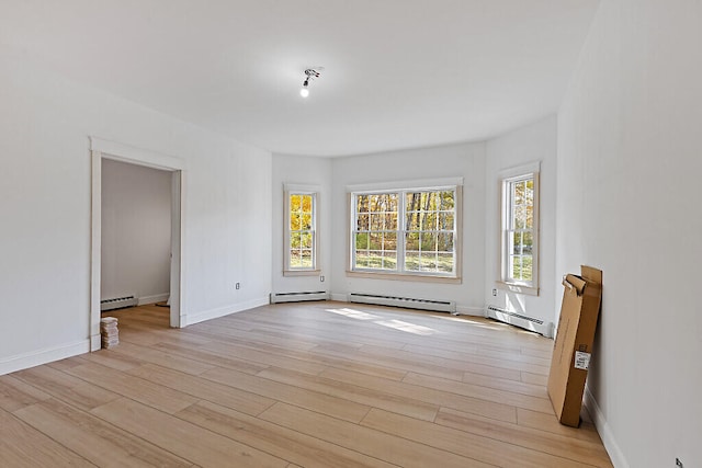 unfurnished room featuring light hardwood / wood-style flooring and baseboard heating