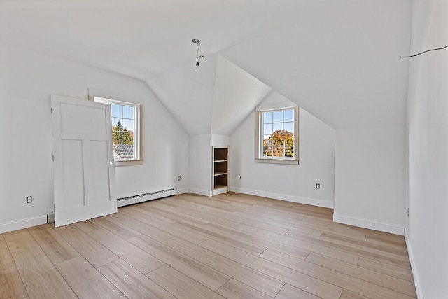 bonus room featuring baseboard heating, light wood-type flooring, and a healthy amount of sunlight