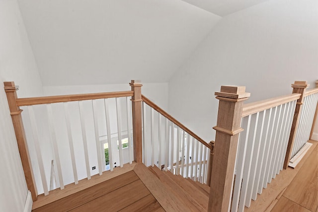 staircase featuring lofted ceiling and hardwood / wood-style floors