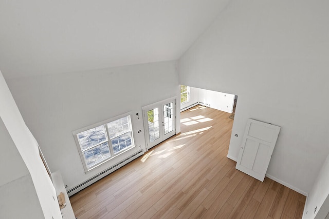 living room featuring baseboard heating, high vaulted ceiling, french doors, and light wood-type flooring