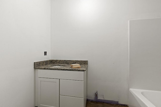 bathroom with vanity and a tub