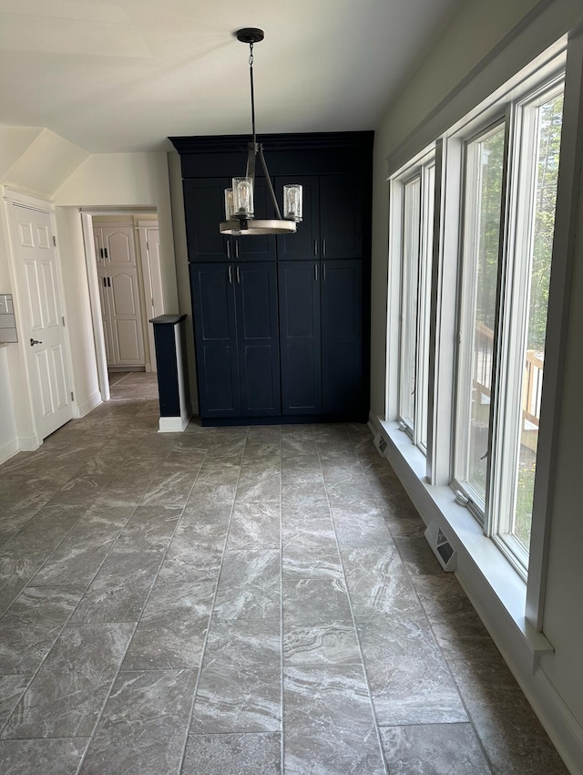 unfurnished dining area featuring light tile floors and a chandelier