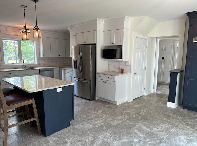 kitchen with tasteful backsplash, a kitchen island, stainless steel appliances, pendant lighting, and a kitchen breakfast bar