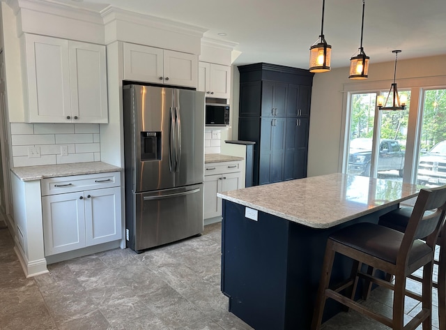 kitchen with decorative light fixtures, stainless steel fridge with ice dispenser, white cabinetry, and tasteful backsplash