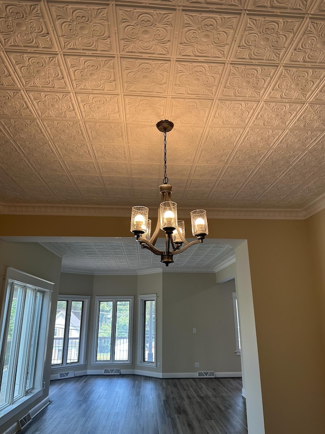 interior space with an inviting chandelier, crown molding, and hardwood / wood-style flooring