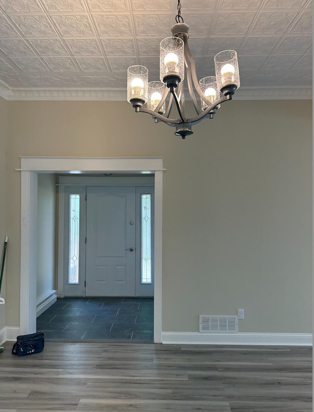 foyer featuring an inviting chandelier, a baseboard heating unit, and dark hardwood / wood-style flooring