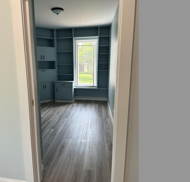 spare room with hardwood / wood-style floors and built in shelves