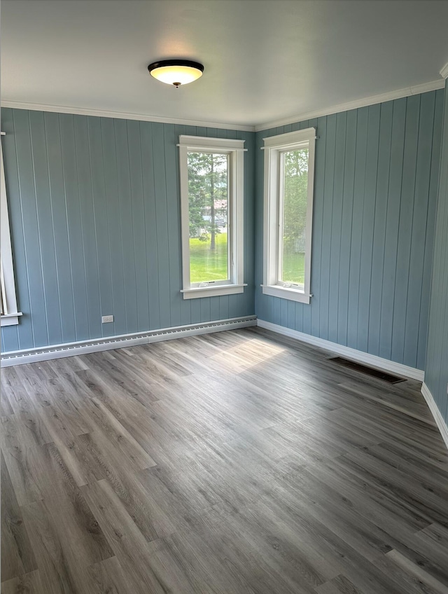 spare room featuring ornamental molding and dark wood-type flooring