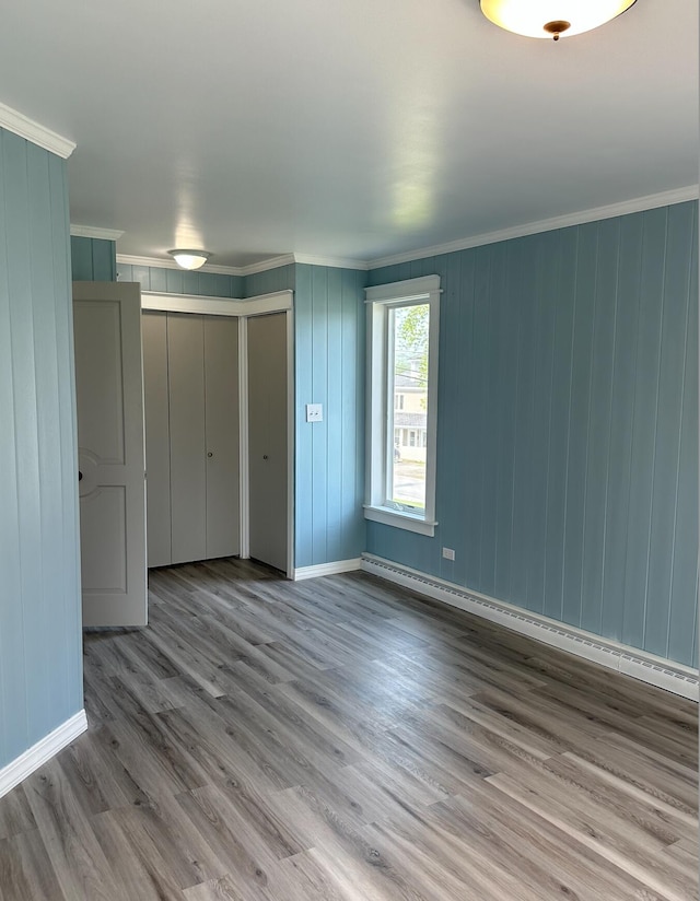 empty room with light hardwood / wood-style flooring and ornamental molding